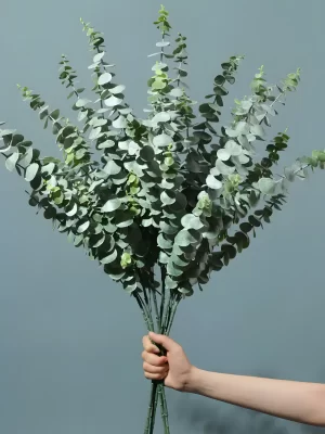 A group of five artificial green eucalyptus stems displayed on a clean backdrop. The image showcases how combining multiple stems can create a lush, abundant appearance, ideal for larger arrangements or standalone displays.