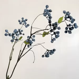 A single, highly realistic artificial blueberry branch, featuring deep blue berries and lush green leaves. The attention to detail makes it a perfect piece for floral arrangements or as a standalone decorative element to bring a touch of nature into any space.