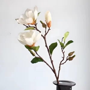 This close-up image highlights the realistic stamen of the artificial magnolia, which adds an extra layer of detail and authenticity to the overall design. The natural color of the cream-white stamen contrasts beautifully with the petals.