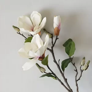 This stunning artificial magnolia features a vibrant purple stamen that adds a pop of color to its soft, white petals. The intricate details of the stamen and lifelike texture make this faux flower a perfect choice for elegant floral displays.