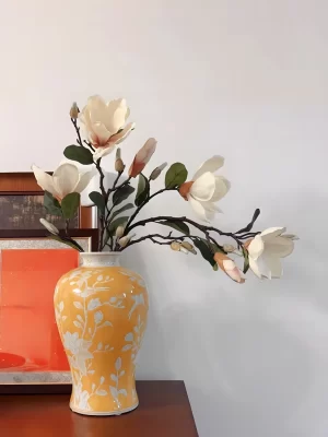 These two faux magnolia stems are beautifully paired with a classic cream-yellow ceramic vase from Jingdezhen, known for its exquisite porcelain craftsmanship. The vase’s floral patterns perfectly enhance the lifelike magnolia blooms, making it a perfect addition to your living room or office.