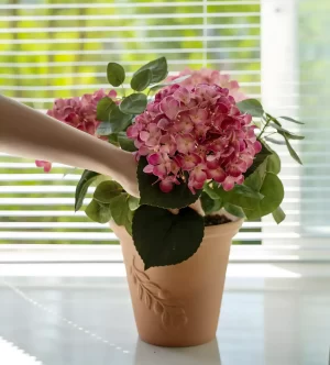 This large pink hydrangea arrangement, placed by a sunlit window, captures the beauty of natural light shining on the vibrant faux blooms. The soft light highlights the realism of the petals, creating a peaceful and inviting atmosphere.