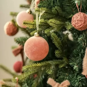 This close-up reveals the intricate details of the pink ornaments against the tree’s realistic green branches. The lifelike foliage and carefully designed ornaments highlight the craftsmanship of this artificial tree, making it an eye-catching centerpiece for festive decor.