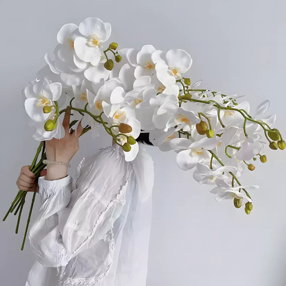 A breathtaking display of six artificial white orchid stems held together, their blooms extending like a delicate bridal veil. This arrangement highlights the versatile beauty of these lifelike orchids for weddings or home decor.