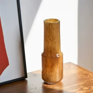 With its sleek form and beautiful amber color, this tall vase makes a statement on its own, bringing a warm glow and minimalist elegance to any surface.