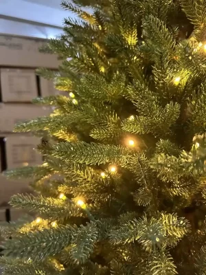 This close-up reveals the enchanting warm yellow lights that wrap around the branches, creating a soft glow. The cleverly hidden wiring enhances the tree's aesthetic without detracting from its natural beauty.